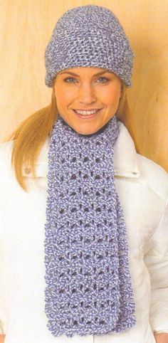 a woman wearing a blue crochet hat and scarf with a knitted necktie