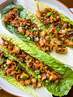 lettuce wraps with chicken and carrots on a white plate, ready to be eaten