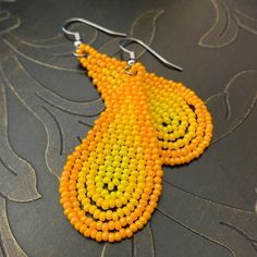 "These soft orange and yellow colored teardrop earrings are light weight and easy to wear. The beads have very slight irregularities, giving these earrings a touch of an organic feel. The French hook ear wires are surgical steel; great for anyone with metal allergies. These earrings measure 2 1/5\" from the top of the ear wire to the bottom of the beaded portion. The beaded teardrop measures 1 7/8\" in length and 1\" in width.  Due to individual monitor settings, the actual color may vary slight Orange Teardrop Earrings As Gift, Orange Beaded Earrings With Round Beads, Orange Round Beaded Earrings With Ear Wire, Yellow Beaded Teardrop Earrings, Yellow Teardrop Beaded Earrings With Colorful Beads, Yellow Teardrop Beaded Earrings With Dangling Beads, Yellow Beaded Teardrop Jewelry, Yellow Teardrop Beaded Earrings As Gift, Yellow Teardrop Beaded Earrings For Gift