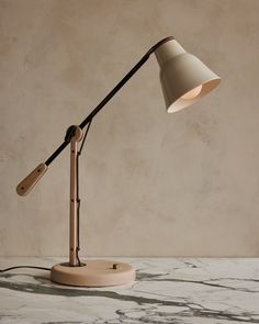 a desk lamp with a wooden base on a marble surface