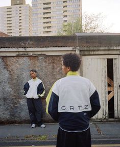 two men standing in front of an old building