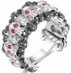 a silver ring with skulls and pink stones on the inside, in front of a white background