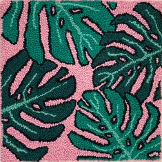 a green and pink rug with leaves on it