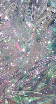 an abstract background with many different colors and patterns on it's surface, as well as glitter