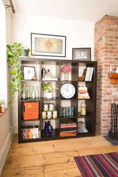 a living room with a fireplace and bookshelf