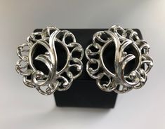 "Vintage Sarah Coventry silver 1960 earrings. These mid century earrings are part of the \"Fancy Free\" collection. The clip on earrings have silver tone open weave of circles with free form leaf design in the center.  Great condition with original ear cushions.  Competitively priced. All jewelry comes in a gift box.  Shop more of our vintage earrings go to https://www.Etsy.com/shop/Historicallyhers" Ornate Silver Clip-on Earrings For Formal Occasions, Vintage Silver Nickel Free Clip-on Earrings, Silver Metal Clip-on Earrings Costume Jewelry, Retro Silver Earrings For Formal Occasions, Silver Clip-on Earrings For Formal Costume Jewelry, Silver Retro Earrings For Formal Occasions, Silver Costume Jewelry Clip-on Earrings For Anniversary, Silver Clip-on Earrings For Formal Events, Silver Clip-on Earrings For Formal Occasions