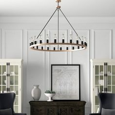 a chandelier hanging from the ceiling in a living room with two chairs and a table