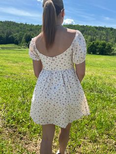 Introducing our Rosette Babydoll Dress, the perfect addition to your summer wardrobe. Made from 100% cotton, this floral mini dress exudes femininity and grace. The model is 5'3" and wearing a size small. Stay cool and stylish all summer long with this must-have dress that runs true to size. Size rec: S - 2-4 M - 4-6 L - 8-10 Square Neck Ditsy Floral Dress For Day Out, Cottagecore Mini Dress For Garden Party, Summer Floral Dress With Ditsy Print And Square Neck, Summer Ditsy Floral Print Dress With Square Neck, Summer Mini Dress With Puff Sleeves For Garden Party, Summer Floral Dress With Square Neck For Day Out, Summer Ditsy Floral Print Mini Dress With Puff Sleeves, Cotton Square Neck Sundress For Day Out, Cute Summer Floral Dress For Daywear