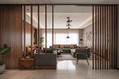 a living room filled with furniture and wooden slats on the wall next to a window