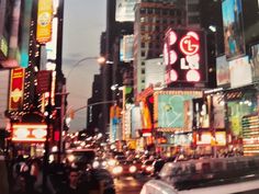 a busy city street filled with lots of tall buildings and neon signs at night time