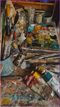 an artist's palette with paint, brushes and other art supplies