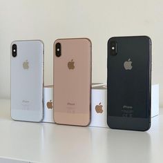 three iphones are lined up on a table