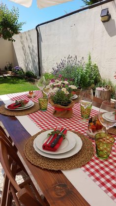 the table is set with plates and utensils on it, along with other place settings