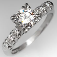 The vintage ring is centered with one (1) round brilliant cut diamond weighing 0.69 carat and set into a four-split prong head. The shoulders of the ring are each accented with three (3), prong set, round brilliant cut diamonds. The ring measures 6.2mm at the top, rises 5.8mm above the finger, tapering to 1.5mm wide and 1.2mm thick at the base of the shank. Classic Diamond Ring With Single Cut Diamonds, Classic Round Cut Single Diamond Ring, Classic Diamond Ring With Single Cut Round Stone, Classic Gia Certified Round Diamond Ring, Gia Certified Classic Round Diamond Ring, Gia Certified Classic Diamond Ring With Round Stone, Classic Gia Certified Diamond Ring, Engagement Rings Antique, Vintage Diamond Engagement Ring