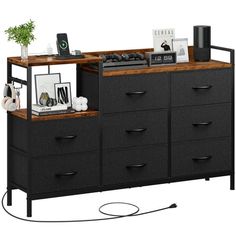 a black dresser with drawers and pictures on the top shelf next to an ipod dock