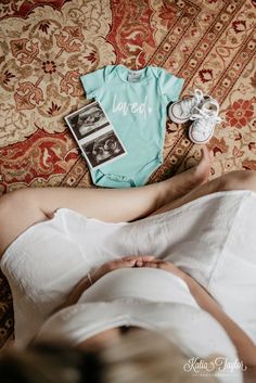 a woman laying on top of a bed next to shoes and a t - shirt