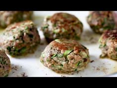 some meatballs are on a white plate and ready to be cooked in the oven