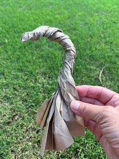 a person is holding a piece of paper in their hand and it looks like an animal's tail