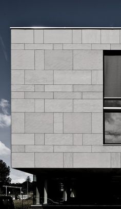 the side of a white building with windows on it's sides and sky in the background