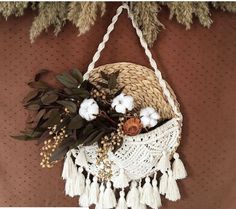 a basket filled with cotton and flowers on top of a table next to a wall