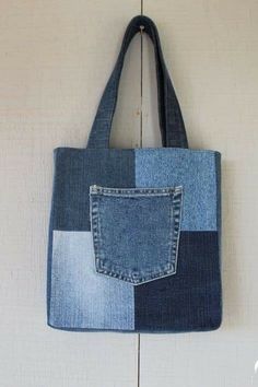 a denim tote bag hanging on the wall with a pocket in front of it