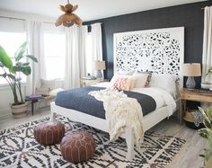 a bedroom with black walls and white furniture