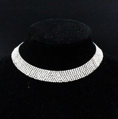 "DESCRIPTION: Elevate your vintage jewelry collection with this designer necklace crafted by Les Bernard during the glamorous 1960s. This choker collar necklace is a true testament to timeless elegance, adorned with a dazzling array of rhinestones that catch the light with every movement. The piece is proudly marked with \"LES BERNARD INC.,\" a symbol of its exquisite craftsmanship. While a few stones may have dulled slightly over time, the necklace remains a captivating and treasured accessory. Costume Jewelry Choker With Bling, Costume Jewelry Bling Choker, Costume Choker Jewelry With Bling, Costume Jewelry Bling Choker Necklace, Bling Costume Choker Necklace, Formal Metal Choker With Rhinestones, Evening Rhinestone Metal Choker Necklace, Formal Metal Rhinestone Choker, Formal Rhinestone Metal Choker