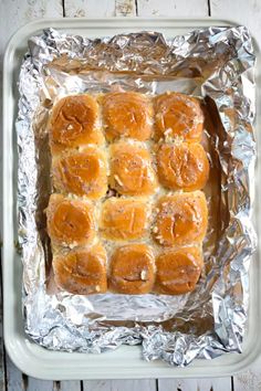 baked bread rolls on tin foil in a baking pan, ready to go into the oven