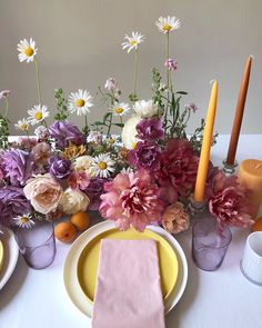 the table is set with flowers and candles