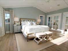 a bedroom with a large bed and white furniture