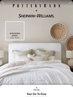 a white bed with pillows and blankets in front of a wall that says pottery barn