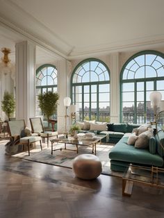 a living room filled with lots of furniture next to large windows and floor to ceiling windows