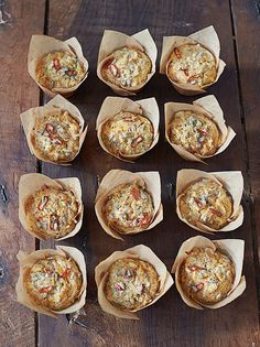 nine muffins with different toppings sitting on a wooden table