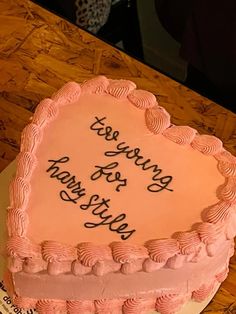 a pink heart shaped cake with writing on it that says, yes serving for harry potter