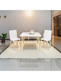 a white table with two chairs and a rug on the floor in front of it