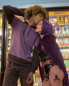 a man and woman standing next to each other in front of a vending machine