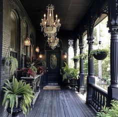 an outdoor porch with potted plants and chandelier