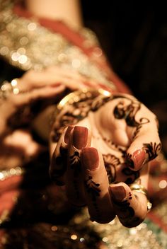 a close up of a person's hands with hennap on