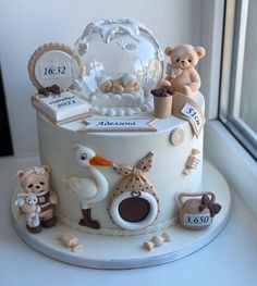 a white cake decorated with teddy bears and other items