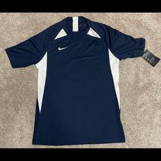 a blue and white nike shirt laying on the floor