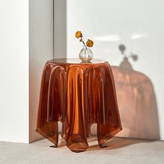 a vase with flowers sitting on top of a small table in front of a mirror