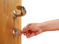 a person opening a door with a key in their hand and another hand holding the handle