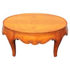 an oval wooden table sitting on top of a white floor