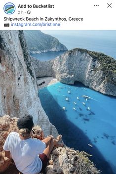 a man sitting on top of a cliff next to the ocean