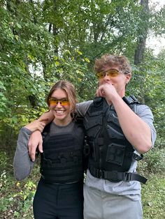 a man and woman posing for a photo in the woods