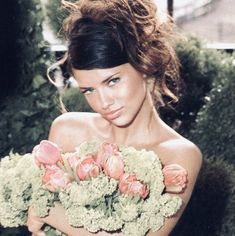 a woman holding a bouquet of flowers in her hands