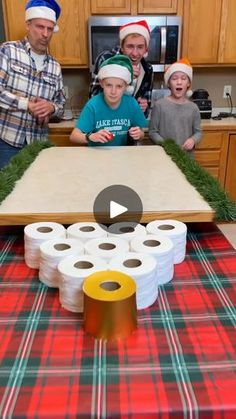 a group of people standing around a table with rolls of toilet paper on top of it