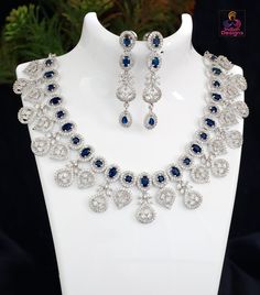 CZ Oval and round Blue sapphire stone necklace, a true statement piece that will elevate any outfit. The Blue sapphire stones are elegantly arranged in an intermittent pattern, creating a captivating contrast of shapes and sizes. The stones are framed by a border of white clear crystals, which add a touch of brilliance and sparkle. The necklace is suspended by an intricate design featuring crystal floral patterns, adding a delicate and feminine touch to the overall design. The combination of the Elegant Blue Necklace With Stone Setting, Sapphire Oval Pendant Necklace For Weddings, Oval Stone Setting Necklace For Wedding, Blue Cubic Zirconia Bridal Necklace, Blue Cubic Zirconia Round Bridal Necklace, Blue Oval Pendant Necklace For Wedding, Blue Elegant Cubic Zirconia Necklace, Blue Wedding Jewelry, Blue Sapphire Stone