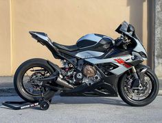 a silver and black motorcycle parked next to a building