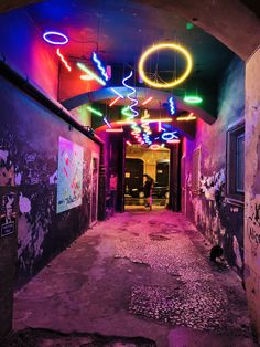 an alleyway with neon lights and graffiti on the walls